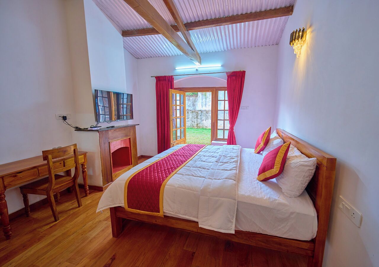 A bedroom with a wooden bed, a desk, and a fireplace.