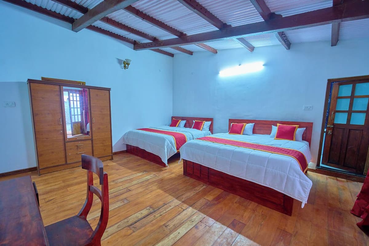 A room with two beds, wooden furniture, and a wardrobe.