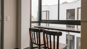 A room with a large window, two wooden chairs, and a small table. - w Magnificent 3BR in the Heart of Barranco (Lima)