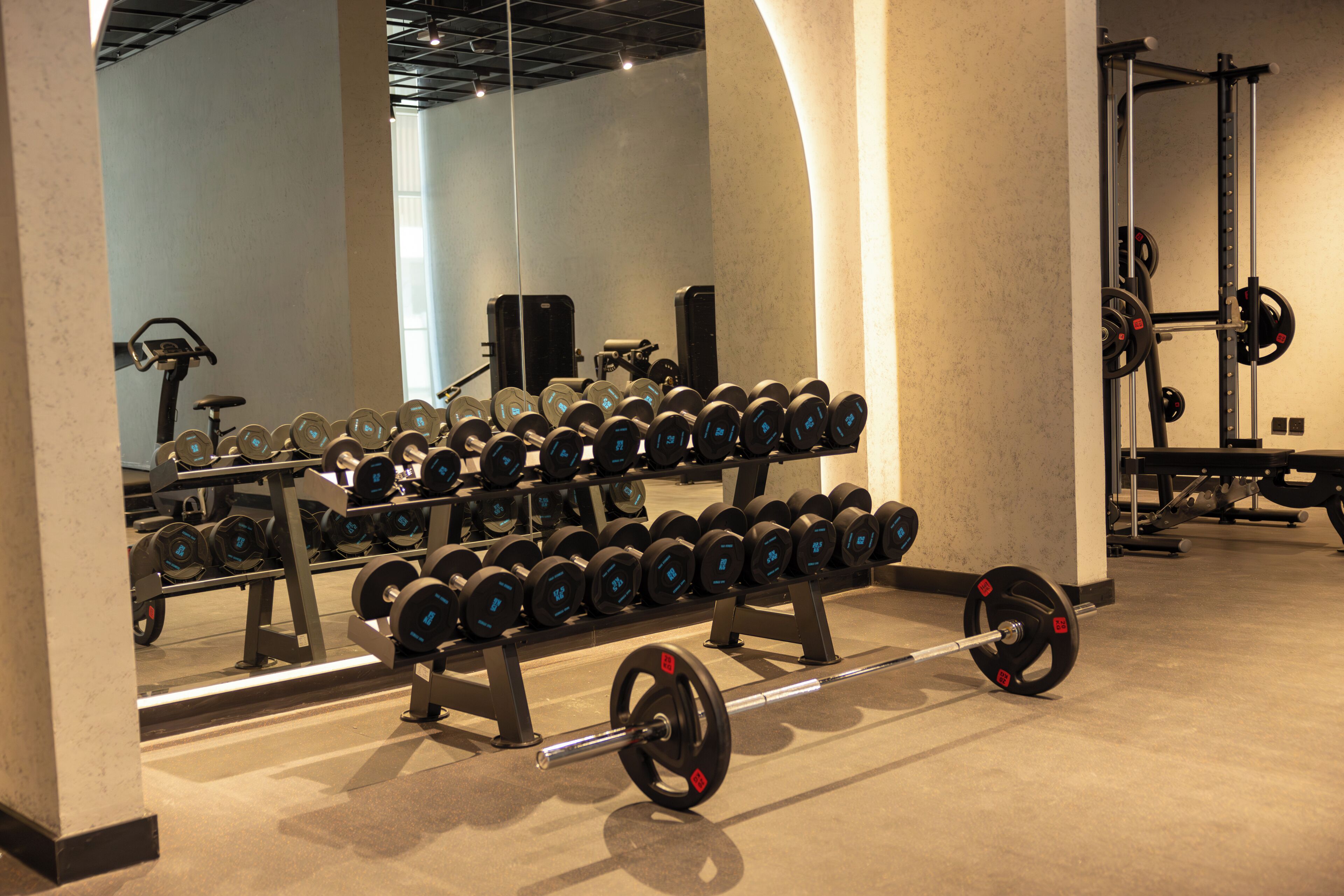 A gym with weightlifting equipment, including dumbbells and barbells.