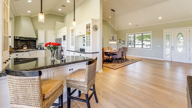 A spacious kitchen with a large island, white cabinetry, and a dining area with a wooden floor and chairs. - Paso Robles Gem w/ On-site Vineyard: Pets Welcome! (Paso Robles)