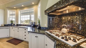 A modern kitchen with white cabinets, a granite countertop, and a stainless steel range hood. - Paso Robles Gem w/ On-site Vineyard: Pets Welcome! (Paso Robles)