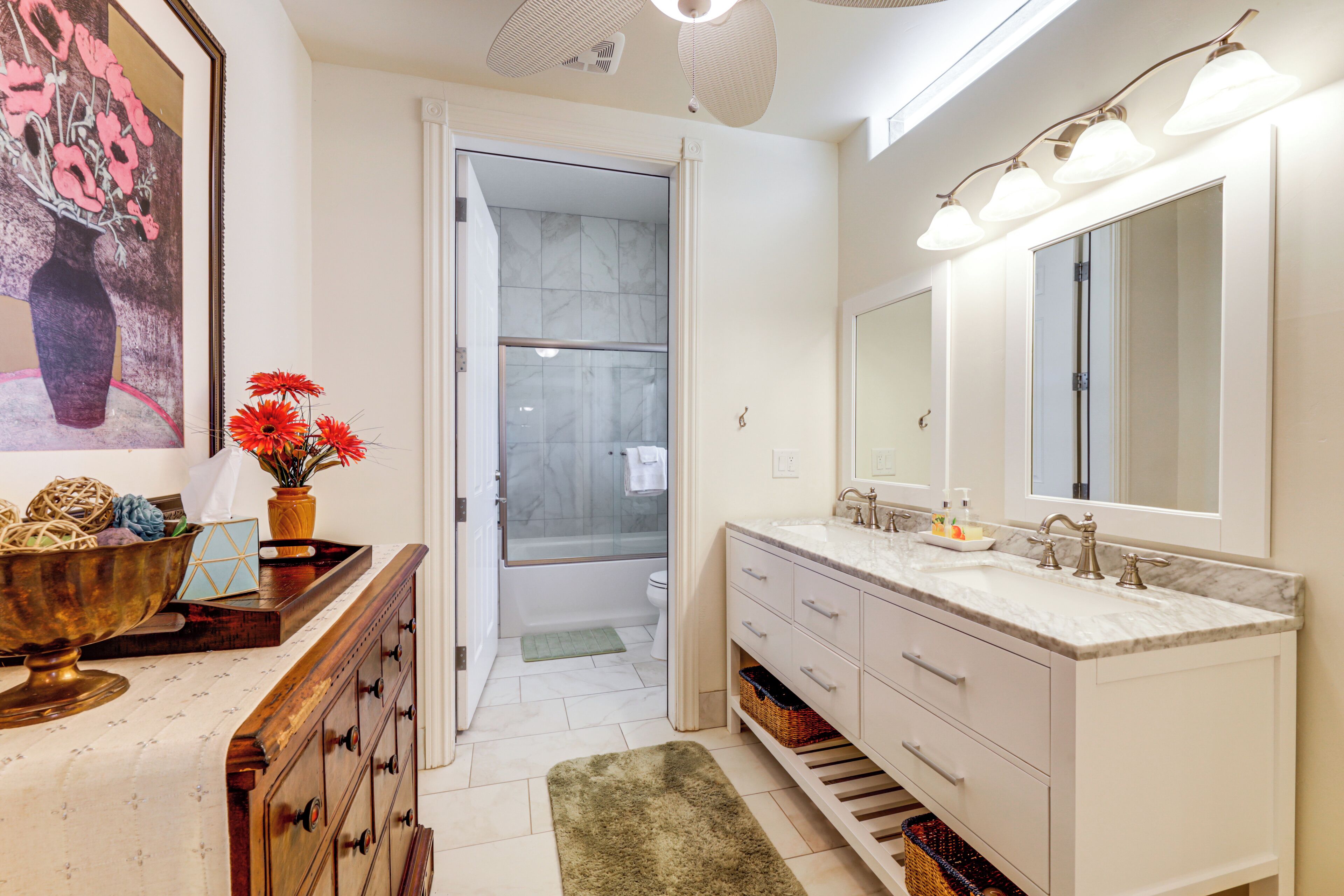 A modern bathroom with a large mirror, dual sinks, and a shower area.