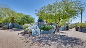 A residential area with a paved driveway, a white staircase leading to a house, and a small garden area with a tree and shrubs. - A-frame w/ Patio & Mtn Views: Arizona Retreat (Apache Junction)
