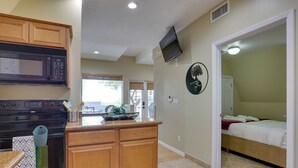 A modern kitchen with wooden cabinets, a microwave, and a countertop with kitchen utensils. - A-frame w/ Patio & Mtn Views: Arizona Retreat (Apache Junction)