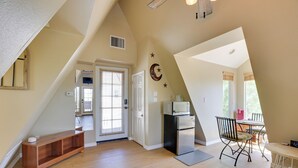 A spacious kitchen with a wooden bench, a refrigerator, and a dining area with a chair and table. - A-frame w/ Patio & Mtn Views: Arizona Retreat (Apache Junction)