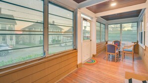 A sunroom with large windows, wooden flooring, and a seating area with two chairs. - Belmont Home < 3 Mi to Harvard Square! (Belmont)