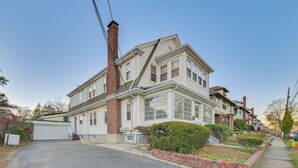 A two-story house with a garage, a brick chimney, and a well-maintained front yard with a small garden and a pathway leading to the entrance. - Belmont Home < 3 Mi to Harvard Square! (Belmont)