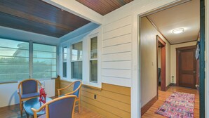 A room with a wooden ceiling, large windows, a dining area with chairs, and a colorful rug leading to a door. - Belmont Home < 3 Mi to Harvard Square! (Belmont)