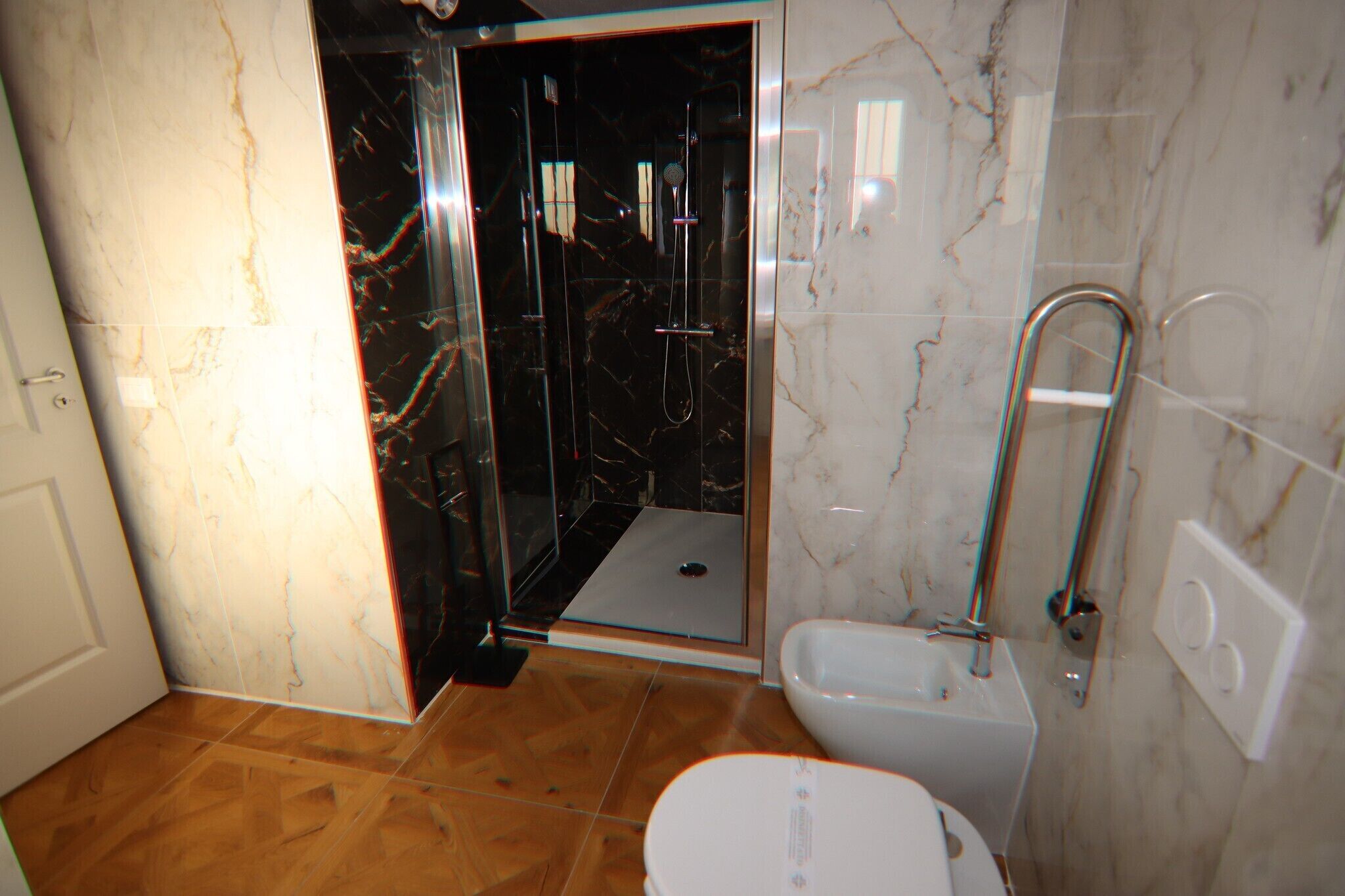 A bathroom with a glass-enclosed shower, a bathtub, and a toilet.