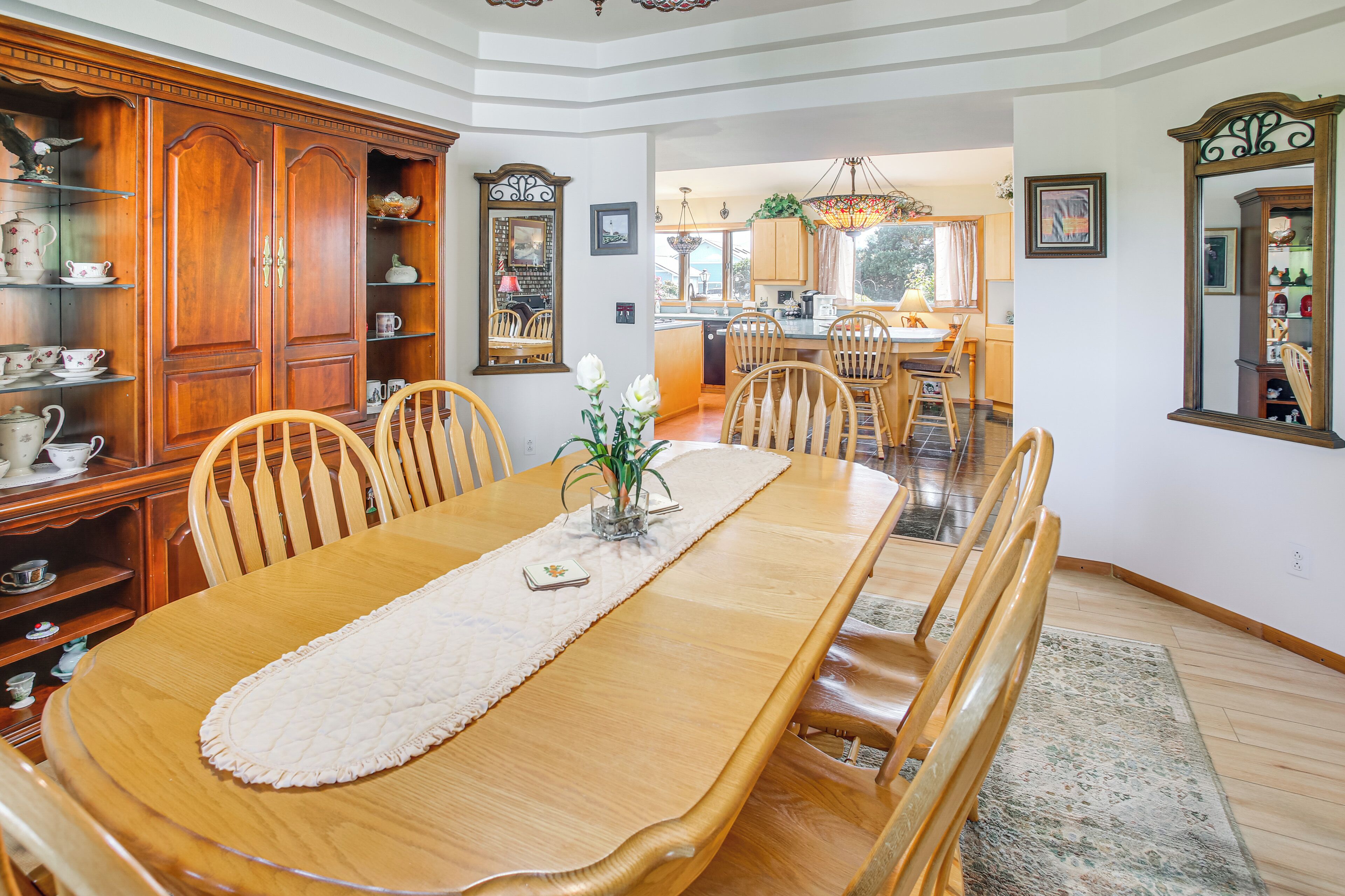 A dining room with a wooden table, chairs, and a buffet cabinet.