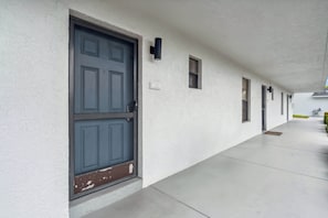 A corridor with a large blue door, small windows, and a white wall. - D-126 Resort Views, Quiet Back End of Resort (Naples)