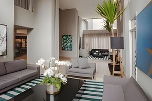 A modern living room with a sofa, coffee table, and potted orchids. - Get a Flat 411 - Jardim Paulista (São Paulo)