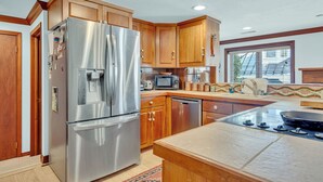 Una cocina moderna con armarios de madera, electrodomésticos de acero inoxidable y una isla grande con estufa a gas.