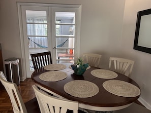 A dining area with a round table, six chairs, and a decorative centerpiece.