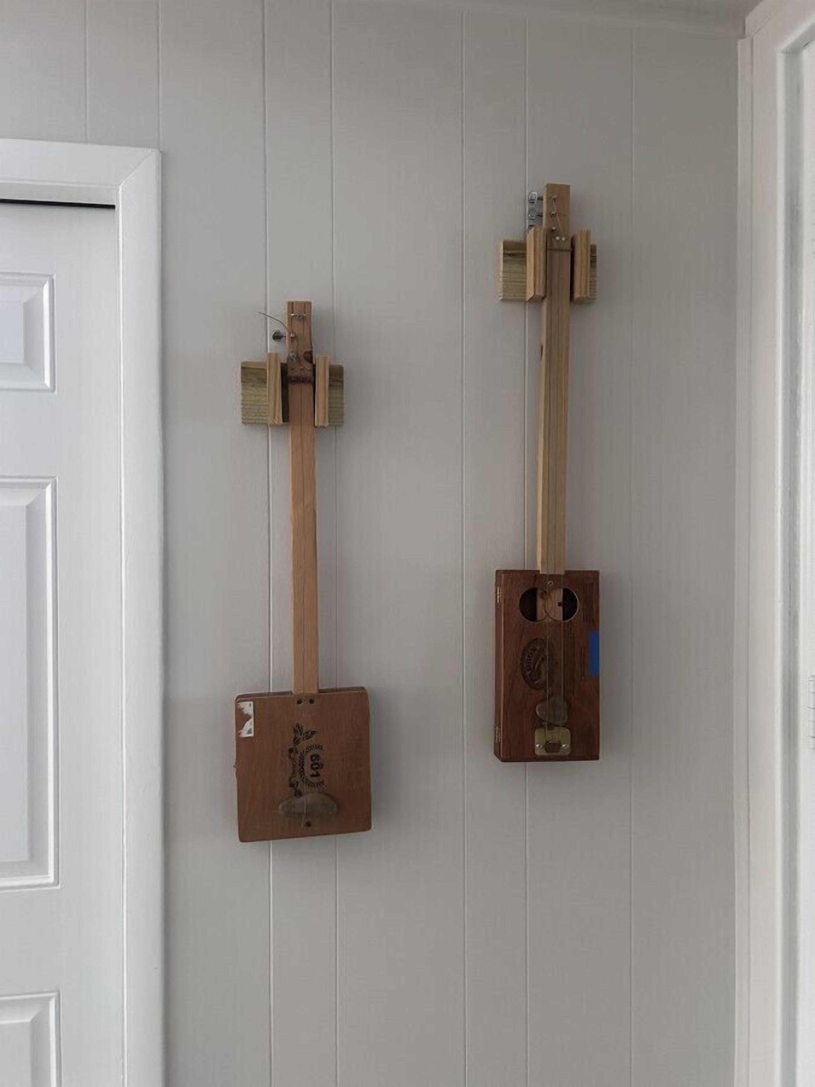 Two wooden objects mounted on a white wall.