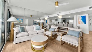 Un salon moderne comprenant un canapé, des fauteuils, une table basse et un coin repas.