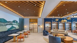 A modern interior with a seating area, tables, and a mural on the wall. - Keptur Hotel (Dosemealti)