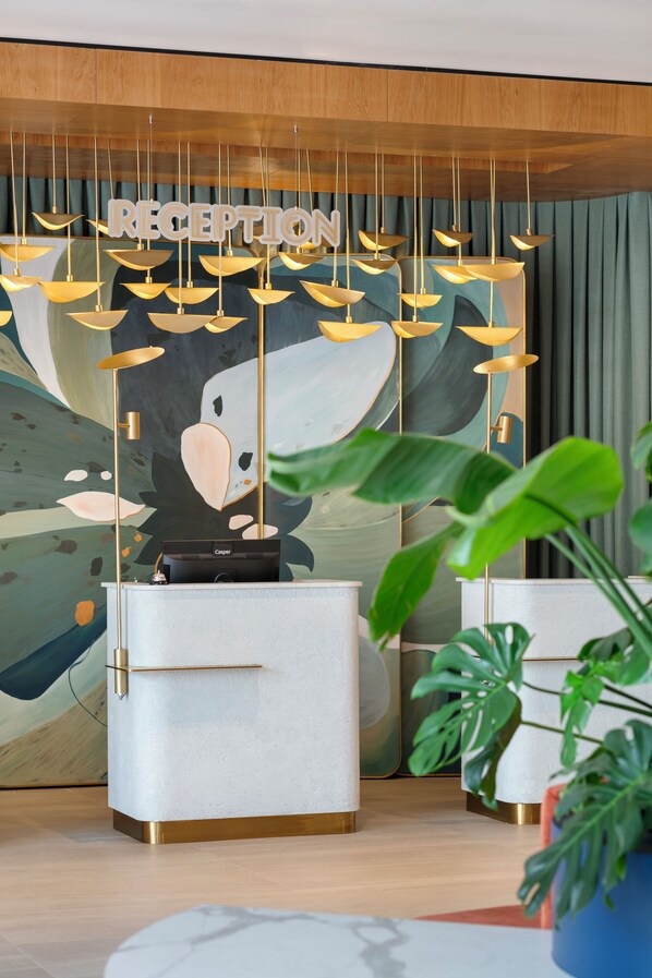 A reception area with a modern design, featuring a reception desk, a large abstract painting, and a 'RECEPTION' sign above the desk. - Keptur Hotel (Dosemealti)