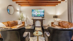 Una sala de estar moderna con sofás de cuero, una mesa de centro y un televisor montado en la pared.