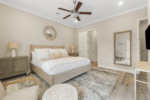A bedroom with a bed, bedside tables, a ceiling fan, a mirror, and a door. - Book 3 Nights & Get 1 Free/See Description*Near 30A* 2 King Suites*Pool & Beach (Santa Rosa Beach)