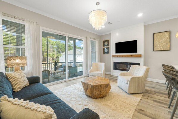 A spacious living room with a large sofa, two armchairs, a wooden coffee table, and a TV mounted on the wall. - Book 3 Nights & Get 1 Free/See Description*Near 30A* 2 King Suites*Pool & Beach (Santa Rosa Beach)