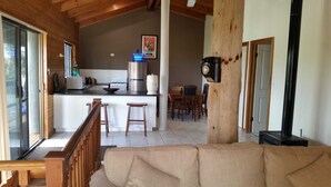 A spacious living area with a wooden ceiling, a kitchen with modern appliances, and a dining area. - Woodstock 3 Francis St, Port Elliot (Port Elliot)