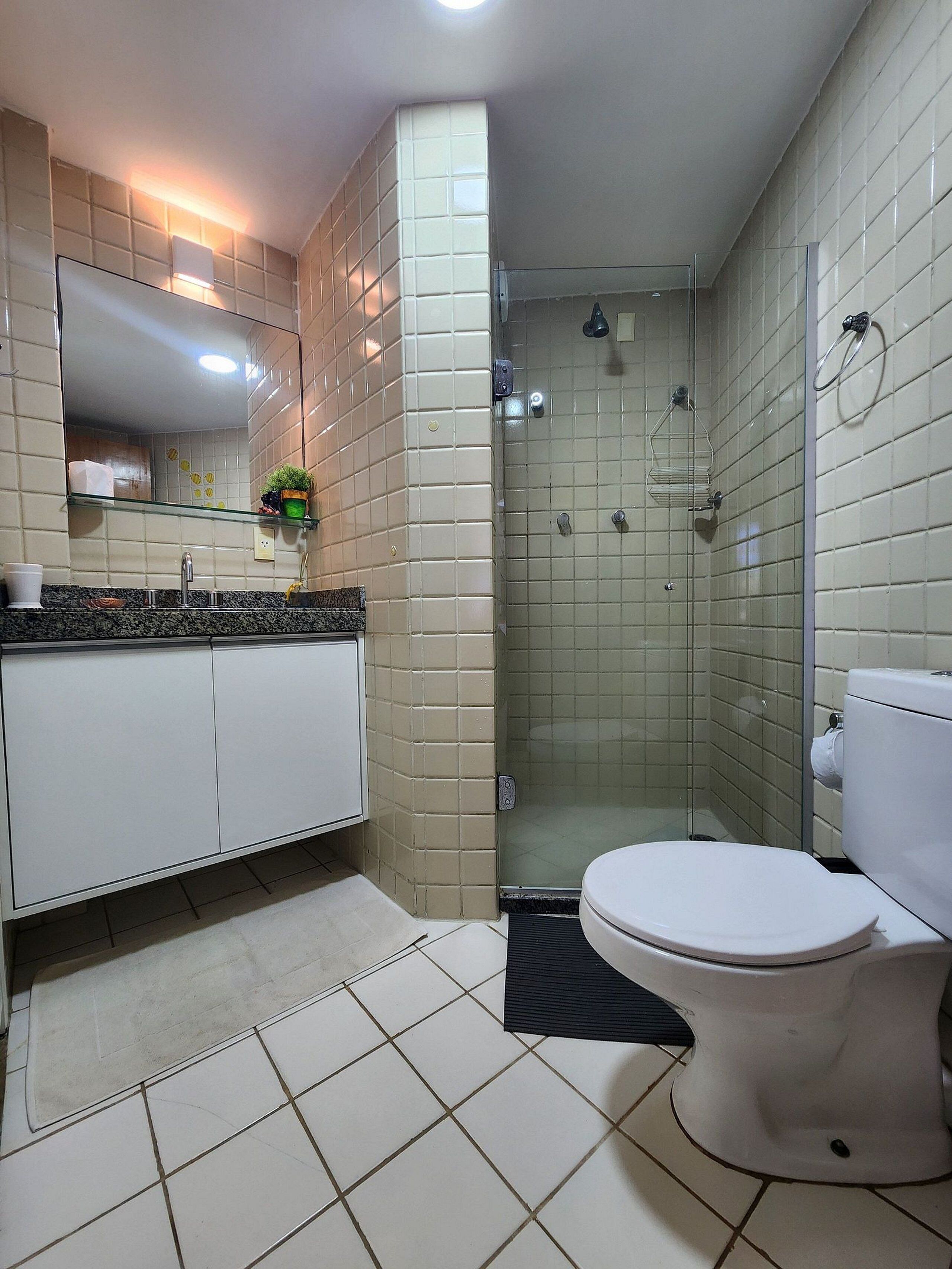 A bathroom with a toilet, sink, and shower.