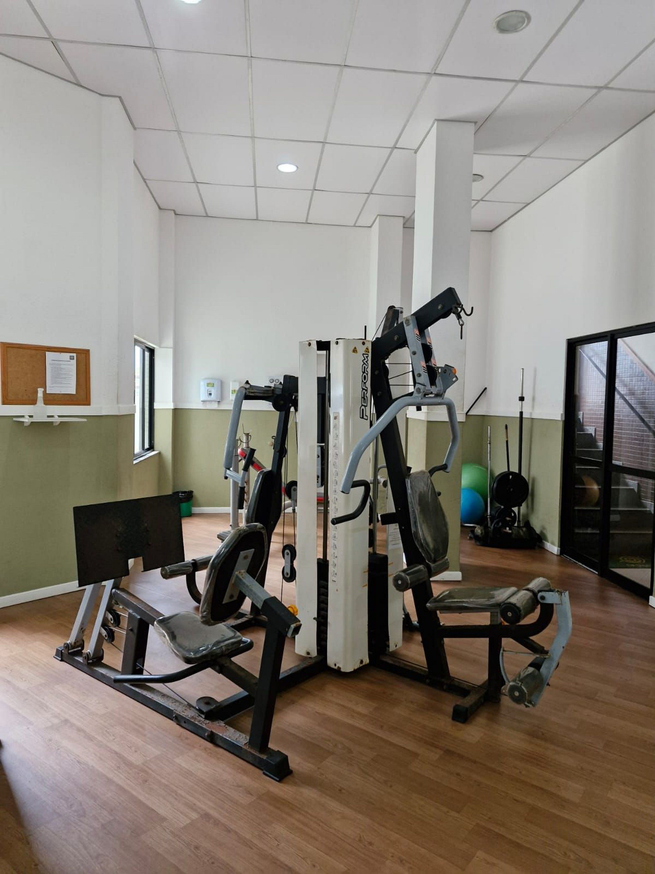 A gym with various exercise equipment, a bulletin board, and a window.