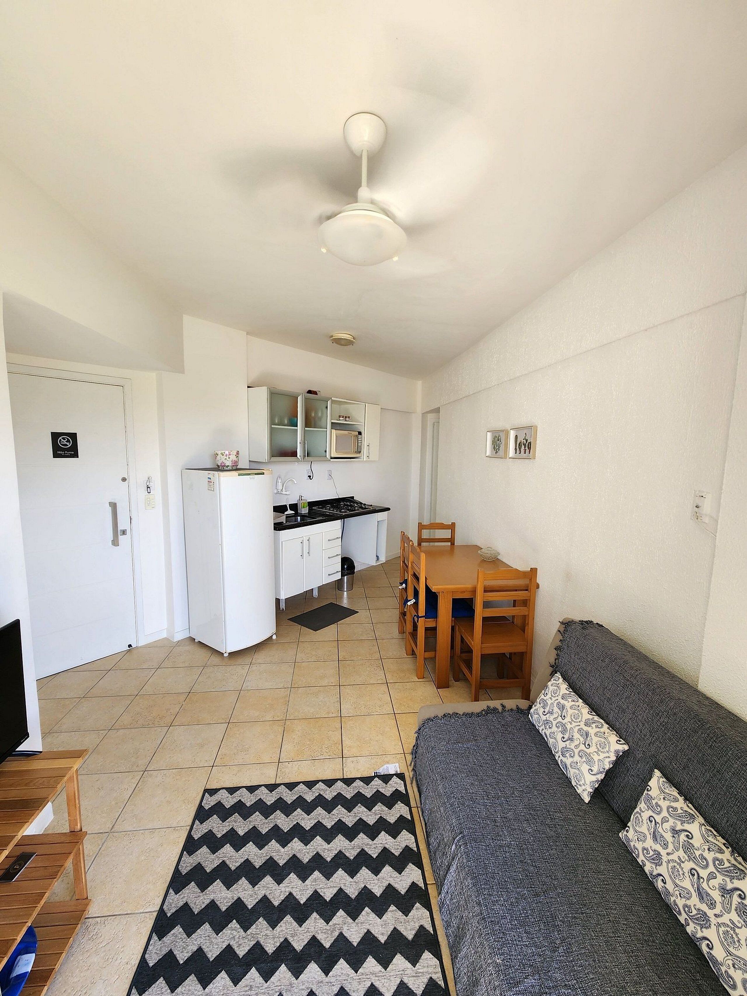 A compact living space with a kitchenette, a dining area, and a sofa.