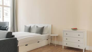 Ein Schlafzimmer mit Bett, Nachttisch, Stuhl und Kommode.