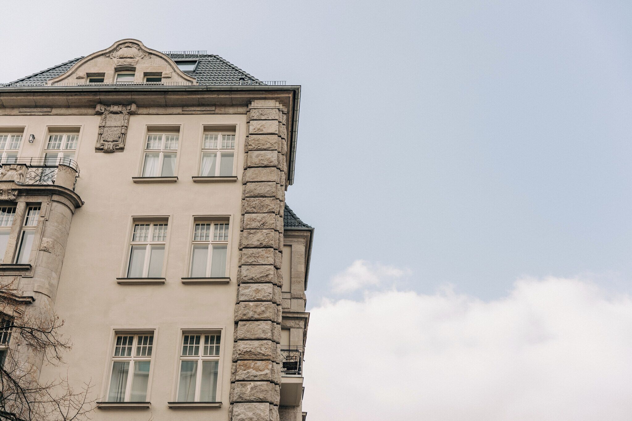 A building with a stone facade, multiple windows, and a balcony.