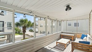 A covered outdoor area with a wooden bench, a table, and a sofa. - Pool, Firepit, Walk To Beach- A Haven By The Sea (North Myrtle Beach)
