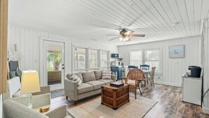 A spacious living room with a sofa, chairs, a coffee table, and a ceiling fan. - Pool, Firepit, Walk To Beach- A Haven By The Sea (North Myrtle Beach)