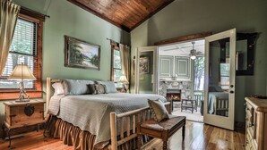 A bedroom with a wooden bed, a bench, a dresser, and a door leading to a balcony. - Elk Horn - Big Canoe GA (Big Canoe)