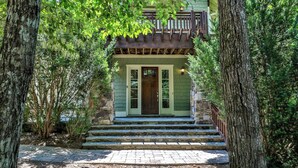 A two-story house with a green facade, a wooden balcony, and a stone staircase leading to the front door. - Elk Horn - Big Canoe GA (Big Canoe)