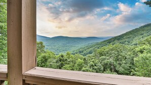 A view from a wooden deck overlooking a forested mountain range. - Endless Sky Lodge - Big Canoe GA (Big Canoe)