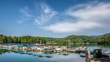 A marina with boats docked, surrounded by forested hills.
