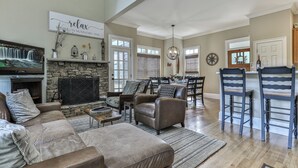 A spacious living room with a stone fireplace, a television, and comfortable seating. - Mountain Time - Big Canoe GA (Big Canoe)