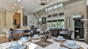 A spacious dining area with a high ceiling, a staircase, and large windows. - Mountain Time - Big Canoe GA (Big Canoe)