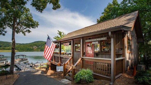 Une cabane en bois avec un quai, un drapeau américain et un panneau indiquant qu’un permis de pêche est obligatoire.