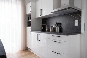 Kjøleskap, mikrobølgeovn, kjøkkenutstyr og spisebord