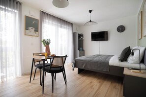 Cozy retreat with a comfortable bed, flat-screen TV, and dining area.
