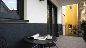 A small balcony with a table, chairs, and a magazine. - Schöne Apartments in der Innenstadt (Osnabrueck)