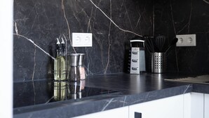 A kitchen with a black marble backsplash, stainless steel appliances, and a reflective countertop. - Schöne Apartments in der Innenstadt (Osnabrueck)