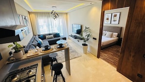 Un apartamento moderno con cocina, comedor, sala de estar y un dormitorio.