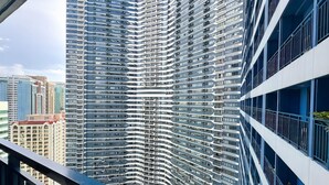 A high-rise building with a modern architectural design, featuring a curved facade and multiple balconies. - 1BR Makati, Air Residences M005 (Makati)