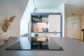 Een koelkast, een magnetron, een kookplaat, een vaatwasser