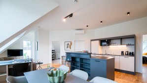 A modern kitchen with a central island, built-in appliances, and a dining area with a table and chairs. - Vienna Residence, Prater - Exhibition Center #6485 (Vienna)