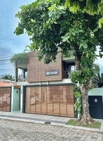 Un edificio moderno con un cartello che riporta la scritta 'HOSPEDARIA' e un grande albero di fronte.